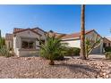 Desert-landscaped single-story home with cacti, palm trees, and a tile roof, and a two-car garage at 19740 N Wind Rose Way, Surprise, AZ 85374