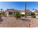 Charming single-story home with desert landscaping including cacti, shrubs, and a two-car garage at 19740 N Wind Rose Way, Surprise, AZ 85374