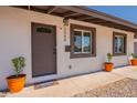 Close-up of the front door with charming potted plants and a 'Welcome' doormat at 2068 E Orange St, Tempe, AZ 85281