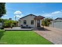 Cozy single-story home features a green lawn, a front deck and quaint curb appeal under a sunny sky at 2316 N Mitchell St, Phoenix, AZ 85006