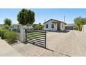 Welcoming home with a manicured lawn, brick driveway, secure gated access, and well-maintained landscaping at 2316 N Mitchell St, Phoenix, AZ 85006