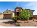 Inviting front exterior of a single-story home with desert landscaping and a brown garage door at 23789 W Chipman Rd, Buckeye, AZ 85326
