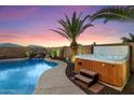 Sparkling pool and spa, complete with a waterfall feature and tropical landscaping at 2810 N 112Th Ln, Avondale, AZ 85392