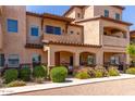 Charming two-story townhome showcasing an arched entryway and manicured front yard with lush flowerbeds at 2821 S Skyline -- # 135, Mesa, AZ 85212
