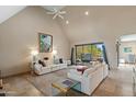 Bright living room with white sofas, vaulted ceiling, sliding doors, and view to the pool area at 3033 E Claremont Ave, Phoenix, AZ 85016