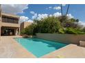 Stunning swimming pool surrounded by lush desert landscaping, featuring flower beds at 3033 E Claremont Ave, Phoenix, AZ 85016