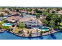 Expansive home overlooking a lake featuring a pool, patio, well-manicured landscaping, and scenic waterfront views at 3112 N 110Th Ave, Avondale, AZ 85392
