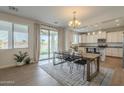 Open dining area with backyard access, modern chandelier, and a view into the kitchen at 3247 N Loma Vis, Mesa, AZ 85213
