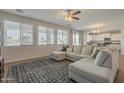Bright living room with a large sectional couch, wood flooring, and multiple windows at 3247 N Loma Vis, Mesa, AZ 85213
