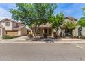 Inviting two-story home with a covered porch, well-kept landscaping, and mature trees at 3552 E Carla Vista Dr, Gilbert, AZ 85295