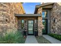 Beautiful stone clad duplex featuring dual front doors with modern black frames at 37200 N Cave Creek Rd # 1122, Scottsdale, AZ 85262