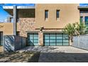 Modern home featuring an attached two-car garage with frosted glass doors and a stone facade at 37200 N Cave Creek Rd # 1122, Scottsdale, AZ 85262