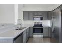 Modern kitchen with gray cabinets, stainless steel appliances, and white countertops at 4031 N Ranier --, Mesa, AZ 85215