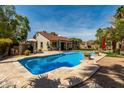 Inviting backyard pool features a stone patio, mature trees, and beautiful desert landscaping at 4525 E Desert View Dr, Phoenix, AZ 85044
