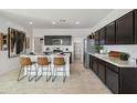 Modern kitchen with stainless steel appliances, marble countertops, and an island with bar seating at 46378 W Lander Ln, Maricopa, AZ 85139