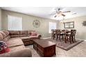 Comfortable living room with a large sectional sofa, a ceiling fan, and a dining area nearby at 553 W Hereford Dr, San Tan Valley, AZ 85143