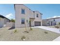 Inviting two-story home with desert landscaping, a two-car garage, and a charming front entryway at 5535 S 240Th Ln, Buckeye, AZ 85326