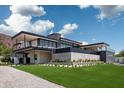 Expansive modern home with sleek lines, a private pool, and lush green landscaping at 5814 E Camelback Rd, Phoenix, AZ 85018