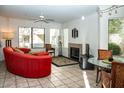 Comfortable living room showcasing a fireplace, ceiling fan, and neutral tile flooring at 7575 E Indian Bend Rd # 1012, Scottsdale, AZ 85250