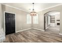 Open dining area with wood-look floors, stylish lighting, and an archway leading to another room at 1051 E Julie Ave, San Tan Valley, AZ 85140