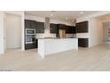 Spacious kitchen featuring a large center island, stainless steel appliances, and dark cabinetry at 1336 E Cherrywood Pl, Chandler, AZ 85249
