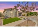 Charming single-story home with well-manicured lawn, beautiful brick driveway, and neutral stucco exterior at 14640 W Dahlia Dr, Surprise, AZ 85379