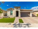 Charming single-story home with well-manicured lawn, beautiful brick driveway, and neutral stucco exterior at 14640 W Dahlia Dr, Surprise, AZ 85379