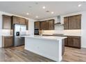 Modern kitchen with wood flooring, stainless steel appliances, an island with a sink, and recessed lighting at 14739 W El Cortez Pl, Surprise, AZ 85387