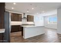 Kitchen showcasing an island with sink, stainless appliances, recessed lights, and hardwood flooring at 14739 W El Cortez Pl, Surprise, AZ 85387