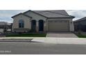 Well-kept single-story home showcasing a tile roof, lush green lawn, and neat brick driveway at 15911 W Montana De Oro Dr, Surprise, AZ 85387