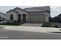 Inviting single-story home with a tile roof, manicured lawn, and brick driveway, perfect for a Gathering at 15911 W Montana De Oro Dr, Surprise, AZ 85387