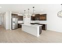 An open-concept kitchen featuring a large island, stainless steel appliances, and ample counter space at 16077 W Remuda Dr, Surprise, AZ 85387