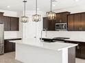 Kitchen island with quartz countertops and stainless steel appliances, including a gas range at 16077 W Remuda Dr, Surprise, AZ 85387