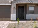Close-up of a home's entrance, highlighting the stylish front door and adjacent landscaping, creating curb appeal at 17809 W Elm St, Goodyear, AZ 85395