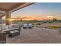 Expansive outdoor patio featuring comfortable seating with a breathtaking sunset view at 18332 E Spring Valley Ct, Rio Verde, AZ 85263
