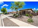 Charming home with a well-maintained yard and stone accents, showcasing curb appeal in a serene neighborhood with blue skies at 19245 W Pasadena Ave, Litchfield Park, AZ 85340