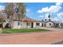 Single-story home with a neat lawn, desert landscaping, and a long driveway, showcasing its curb appeal at 311 N Henkel --, Mesa, AZ 85201