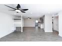 Bright living room with gray floors, ceiling fan, and open concept layout flowing into a modern kitchen at 3128 N 40Th Ave, Phoenix, AZ 85019