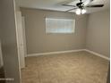 Bedroom featuring tile flooring, neutral colors, fan, closet and a bright window at 3314 W Del Monico Ln, Phoenix, AZ 85051