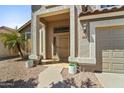 Inviting front entrance with decorative door, desert landscaping, and covered porch at 332 N Cobblestone St, Gilbert, AZ 85234