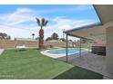 Landscaped backyard featuring a private pool, hot tub, artificial turf, and patio at 530 E Draper St, Mesa, AZ 85203
