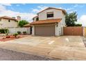 View of the home's exterior with driveway leading to a two-car garage at 5407 W North Ln, Glendale, AZ 85302