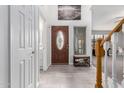 Inviting foyer featuring tiled floors, staircase, and a decorative front door at 5407 W North Ln, Glendale, AZ 85302