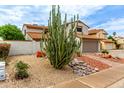 Landscaped front yard featuring desert landscape with a large Saguaro cactus at 5407 W North Ln, Glendale, AZ 85302
