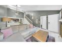 Bright open concept living room with high ceilings, open to the kitchen, and staircase with gallery wall at 633 W Southern Ave # 1131, Tempe, AZ 85282