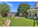 Beautiful backyard featuring artificial grass, a fire pit, and a covered patio at 645 S 54Th St, Mesa, AZ 85206