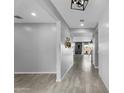Bright entryway featuring wood-look tile flooring, light gray walls, shiplap accent wall, and modern lighting at 13553 N 141St Ln, Surprise, AZ 85379