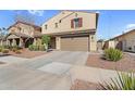Two-story home with a two-car garage, a neutral-toned exterior, tidy landscaping, and a paved driveway at 13553 N 141St Ln, Surprise, AZ 85379