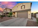 Charming two-story home featuring a well-manicured lawn, a tile roof and a two car garage at 13553 N 141St Ln, Surprise, AZ 85379