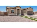 View of a new construction beige home with desert landscaping, artificial turf walkway, and a two-car garage at 14861 S Capistrano Rd, Arizona City, AZ 85123